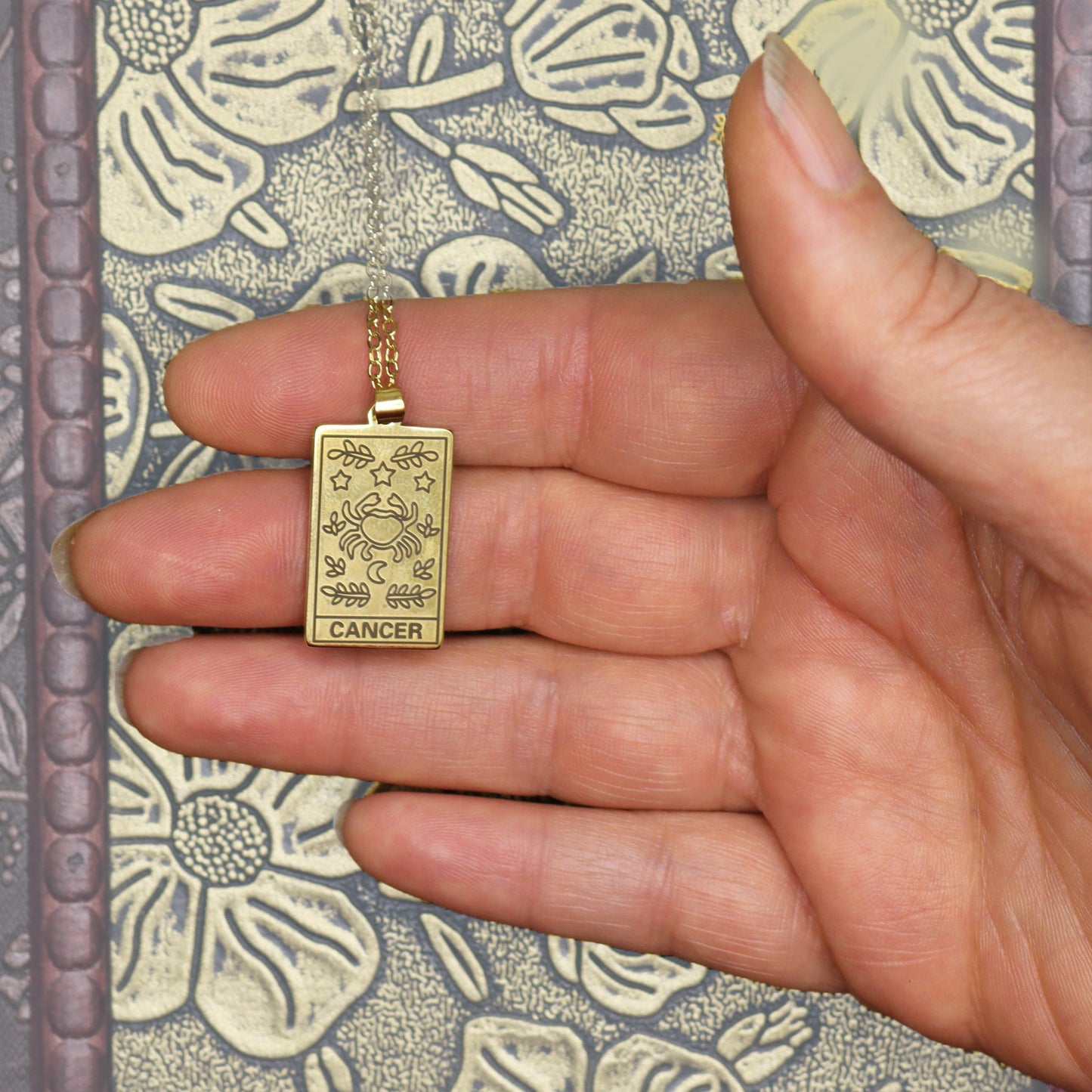 Cancer birthday gift necklace-pendant, Zodiac star-sign 18k gold-plated jewellery shown here with in hand.