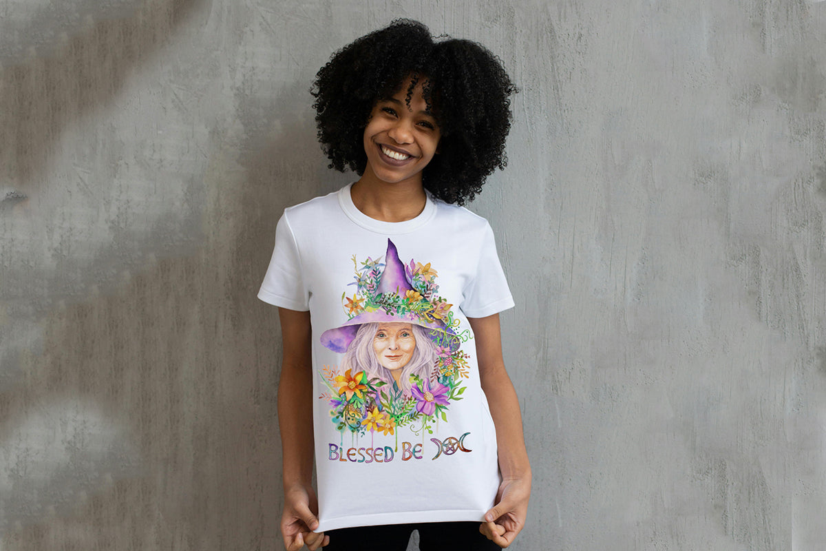 Person wearing a white t-shirt with a colorful graphic design of a witch in a witch hat and flowers, with text 'Blessed Be'.

Downloadable, printable clip art reproduced from a hand-painted wiccan / pagan watercolor painting. An instant-access digital product.