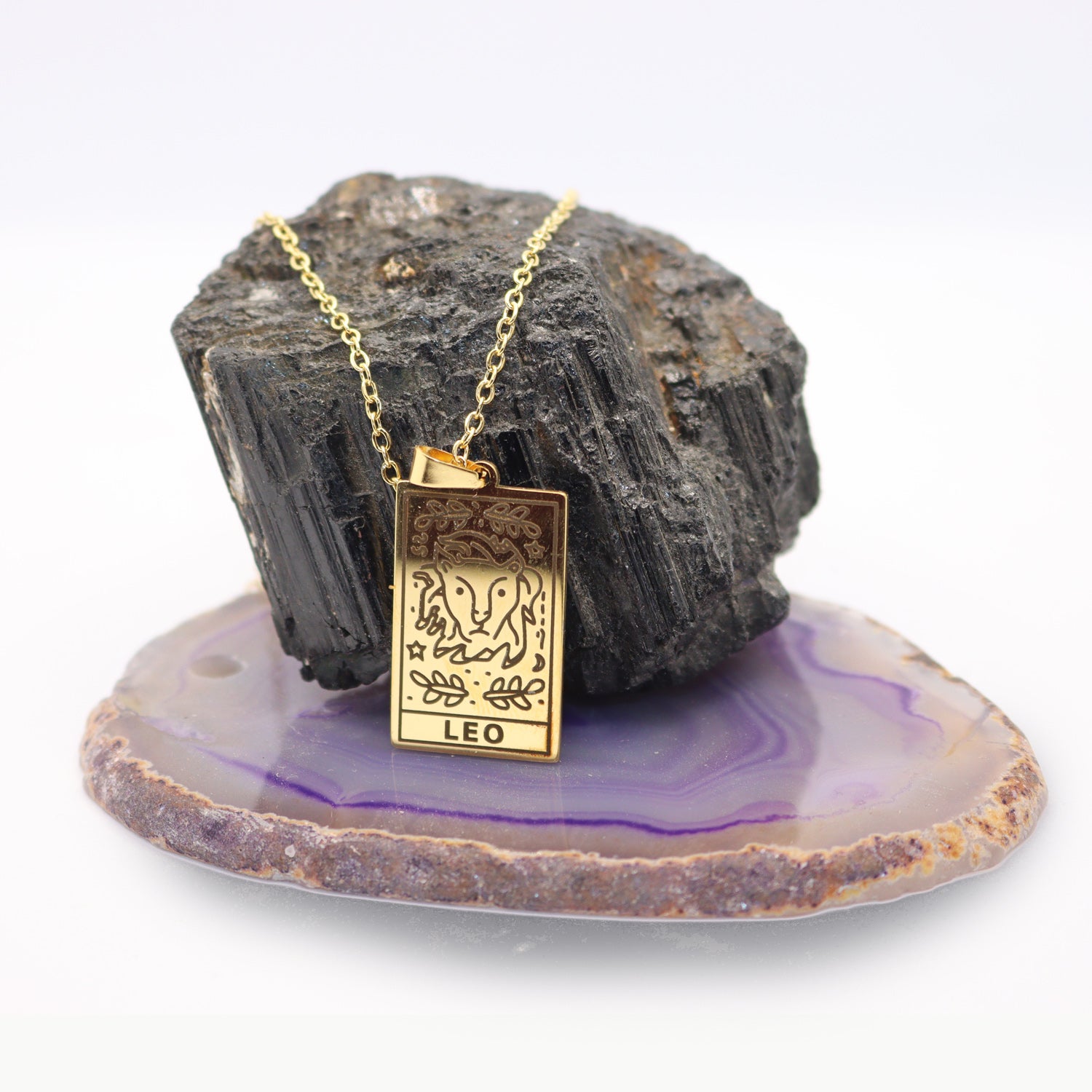 Leo birthday gift necklace-pendant, Astrology Horoscope Zodiac star-sign jewellery displayed with crystals and a rock.